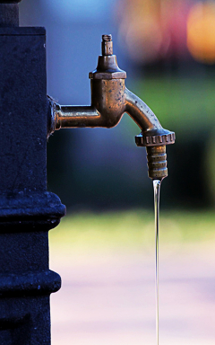 Wasserhahn an einer Säule draußen, von der Seite gesehen